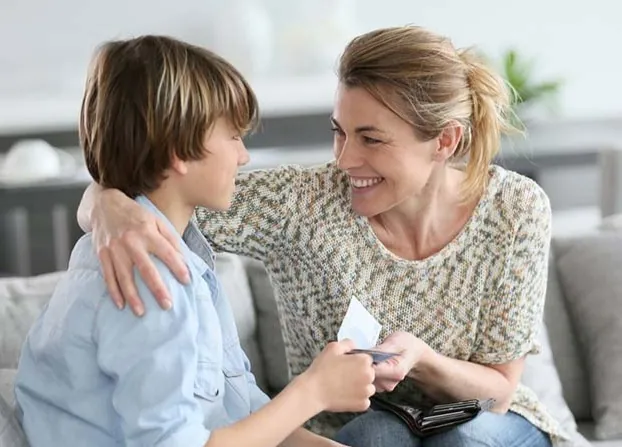 Une mère félicite chaleureusement son fils — un renforcement positif immédiat à la maison