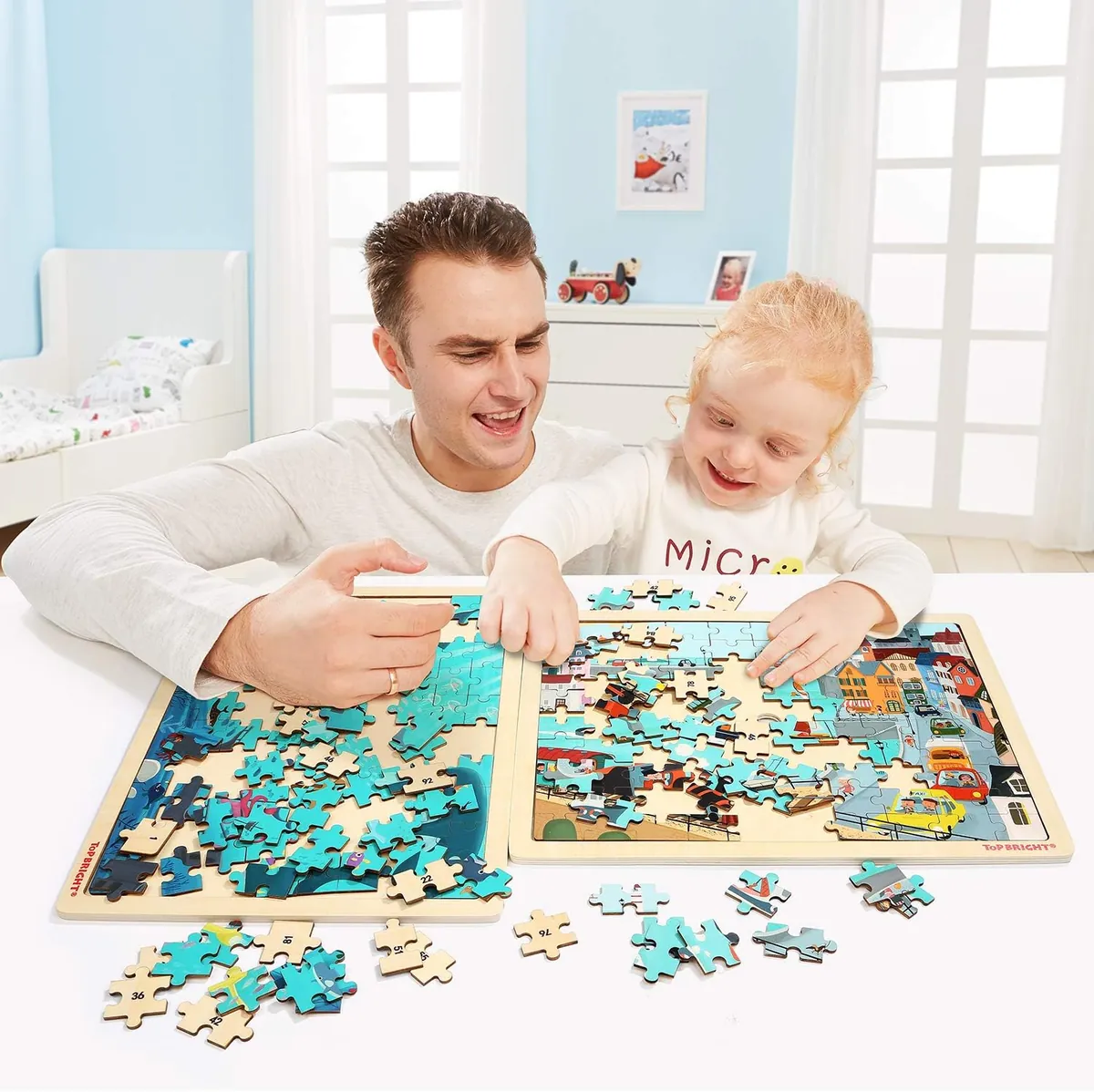 Père et fille qui complètent ensemble des casse-têtes en bois à la table