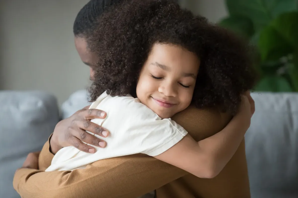 Jeune enfant qui serre fort un parent dans ses bras, un moment de réconfort et de sécurité affective