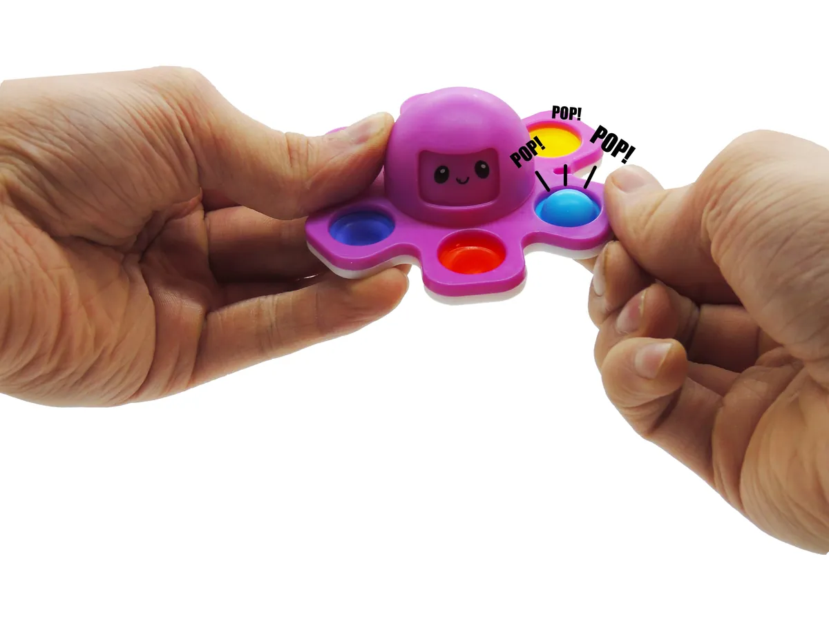 Deux mains écrasent les bulles pop-it sur les bras de la Pieuvre Spinner violette