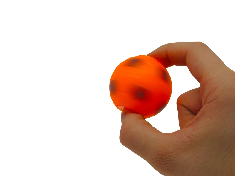 Spinner ballon de soccer orange tenu entre deux doigts