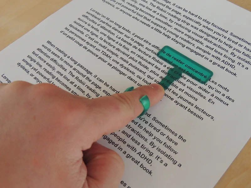 Main qui suit un texte avec le doigt de lecture bleu