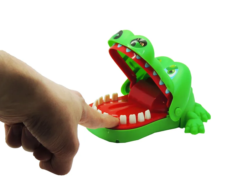 Un doigt appuie sur une dent du bas du crocodile