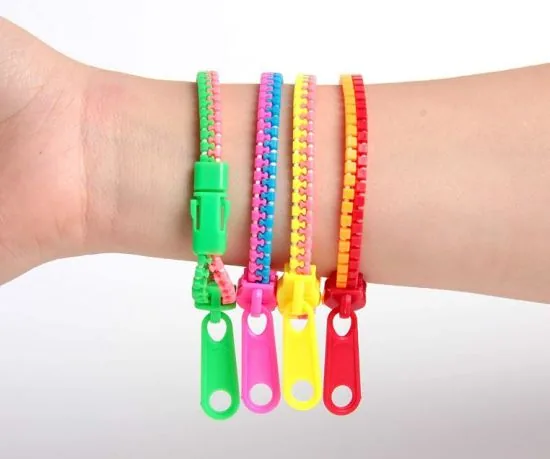 Cinq bracelets à fermeture éclair fluo portés ensemble au poignet