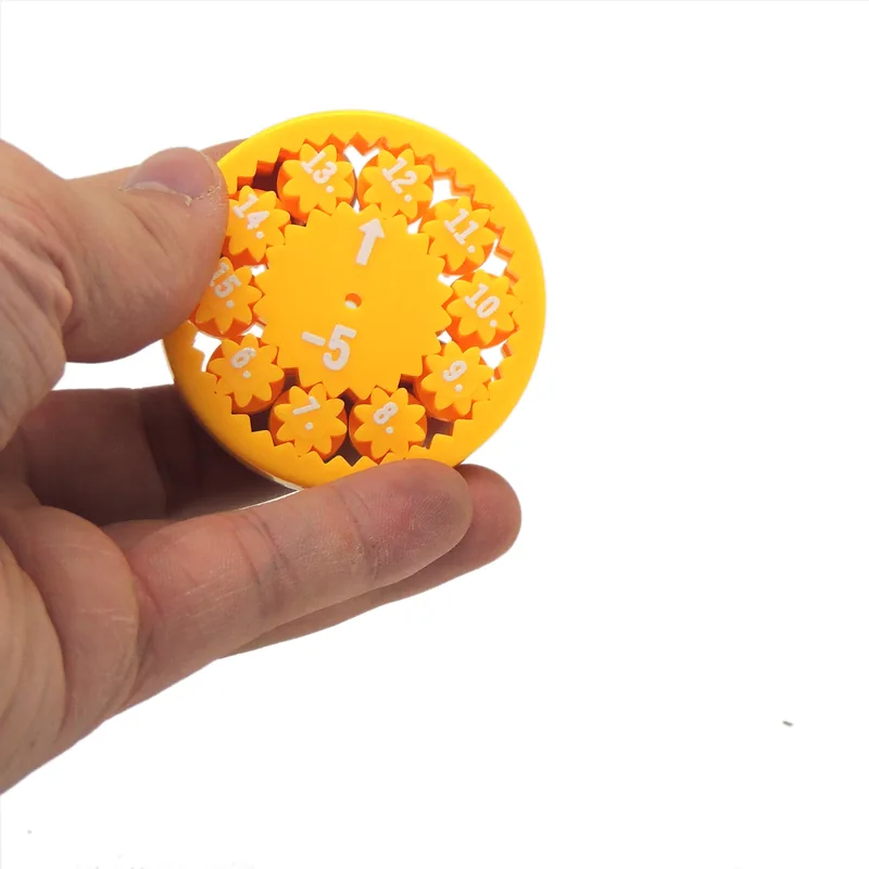 Main qui tient une toupie mathématique jaune affichant 5+
