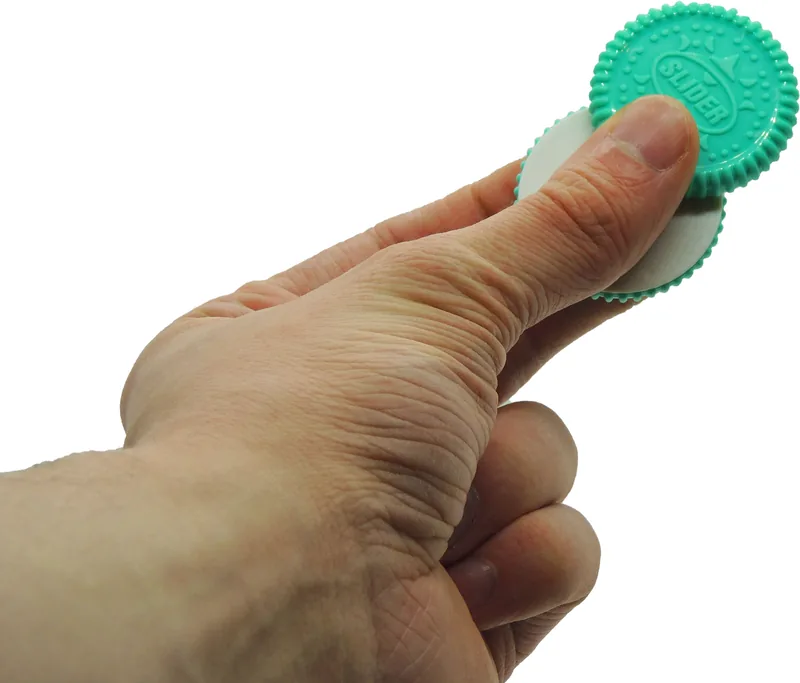 Pouce qui fait glisser les deux disques du biscuit magnétique